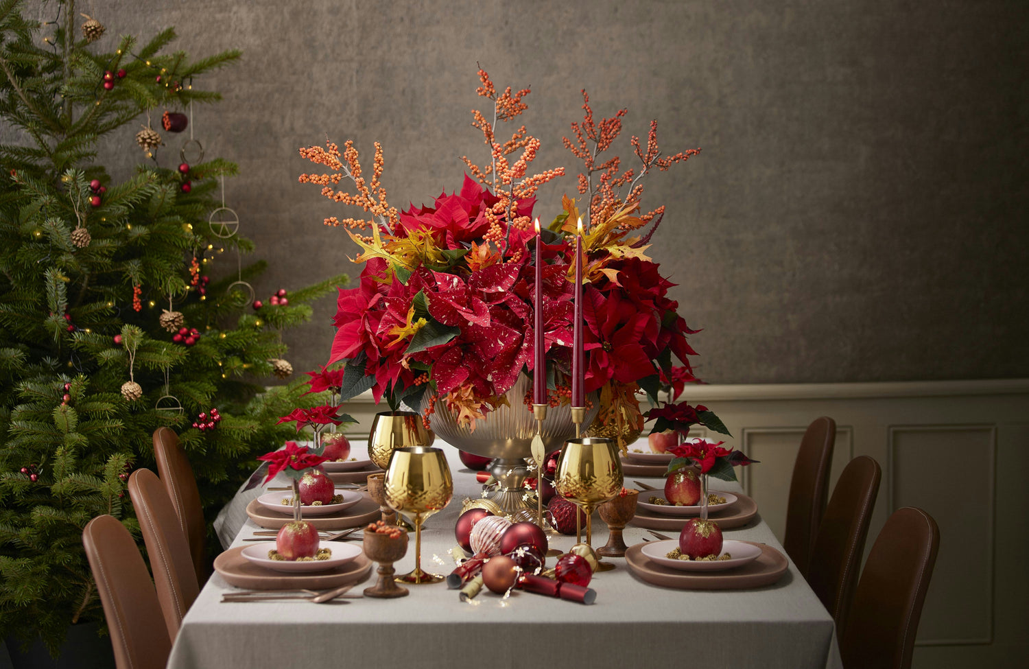 A Christmas dinner table adorned with a festive floral arrangement. Photo by Charlotte Cowell on Unsplash.