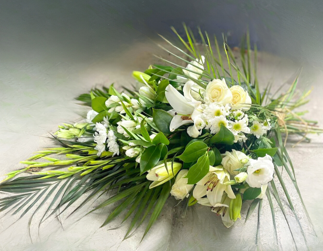 Casket/Funeral Sheaf with an arrangement of white flowers and fresh greenery.