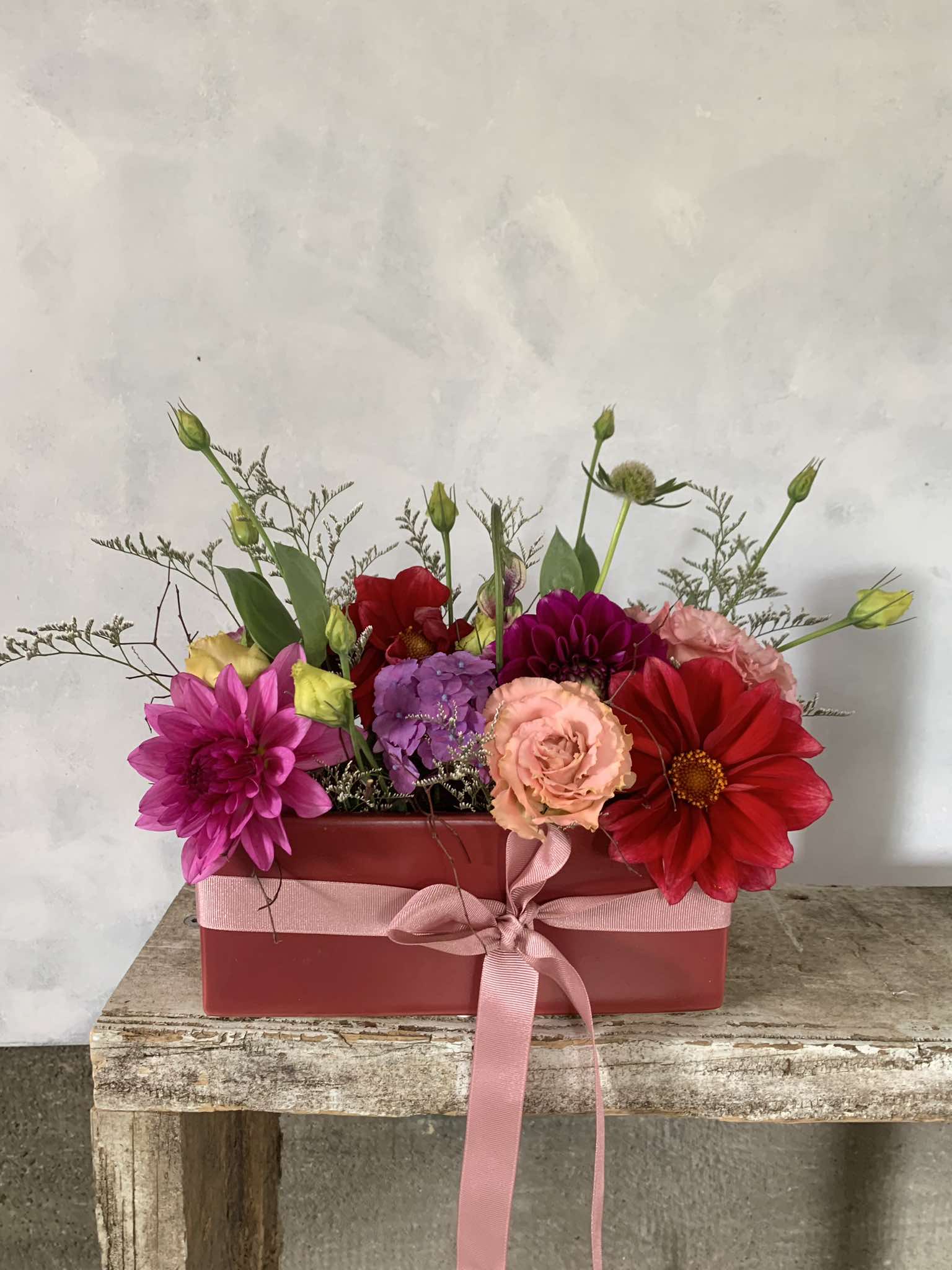 Be Mine floral arrangement made with pink, red and purple flowers and green foliage, presented in a red vase tied with matching ribbon. Perfect for Valentines Day!