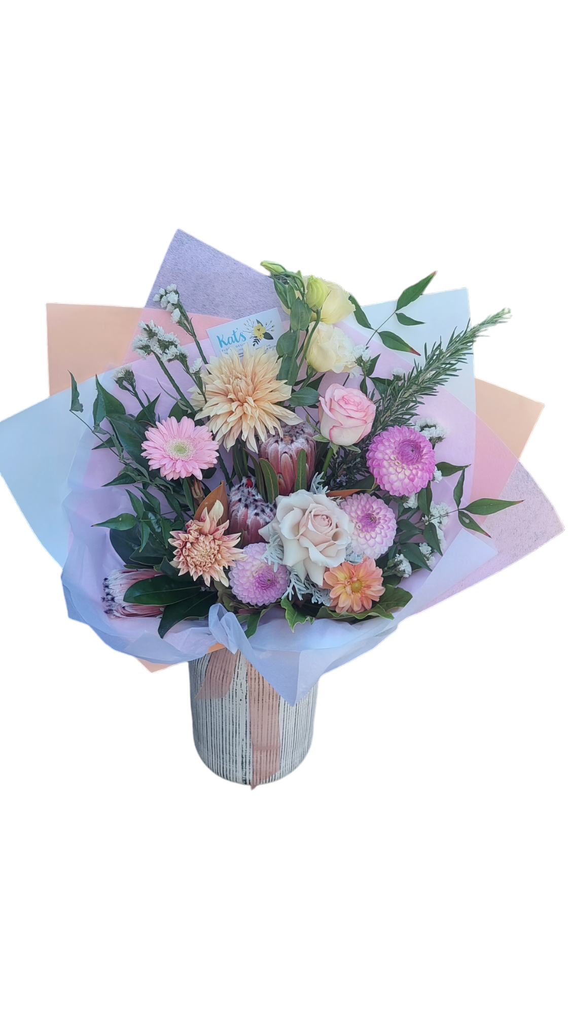 Pastel-Licious floral bouquet made with pink, peach and white flowers, wrapped in matching tissue paper.