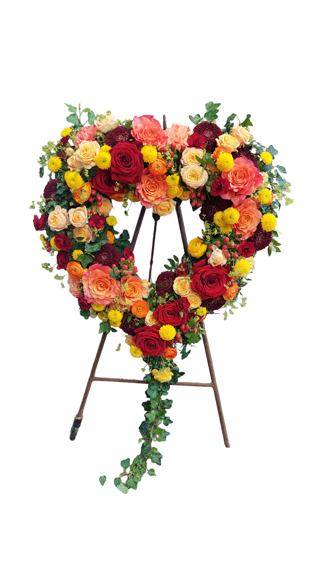Tribute Heart for funerals attached to a vertical stand, made with warm-toned flowers and foliage in the shape of a loveheart.