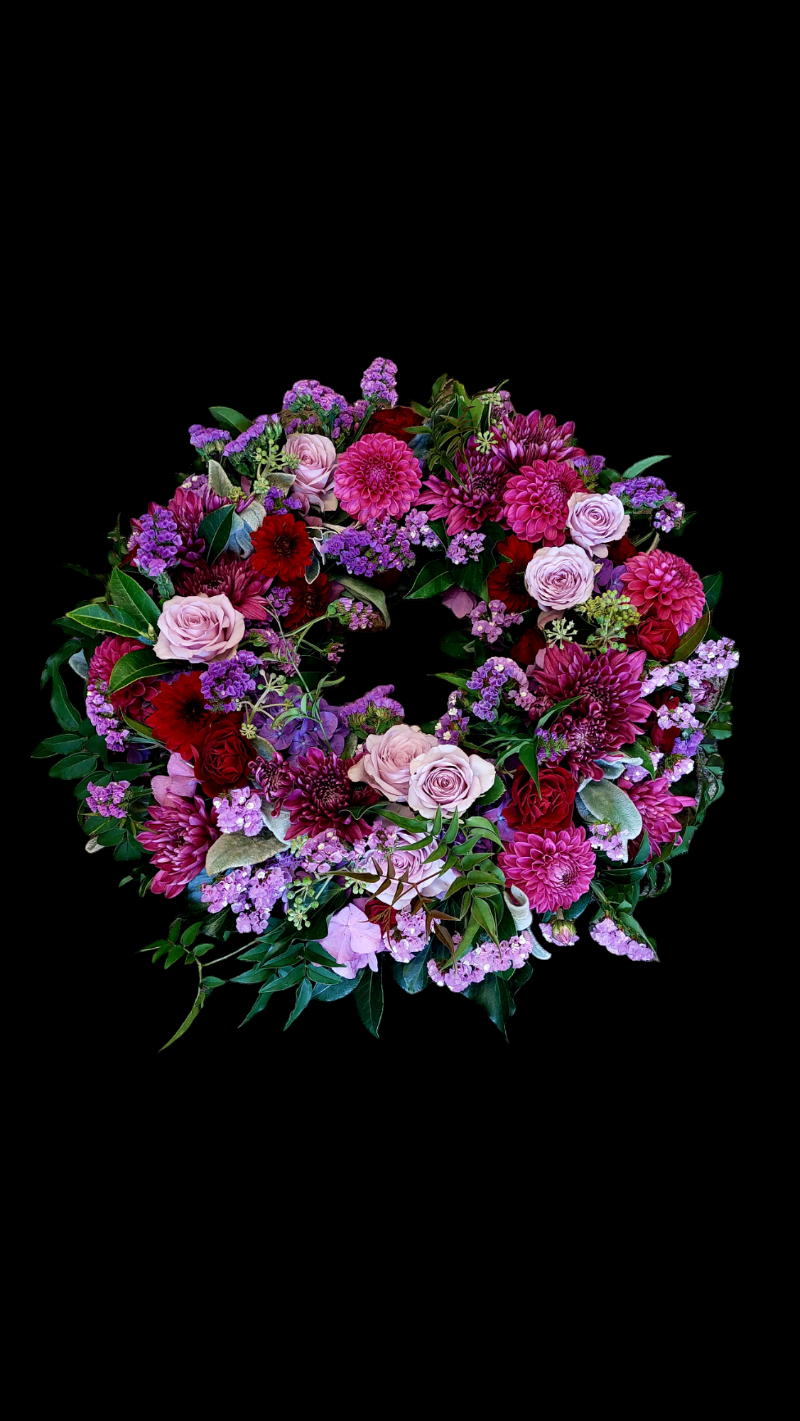 Wreath of Remembrance for funerals and memorials made with bright purple and pink flowers and lush foliage