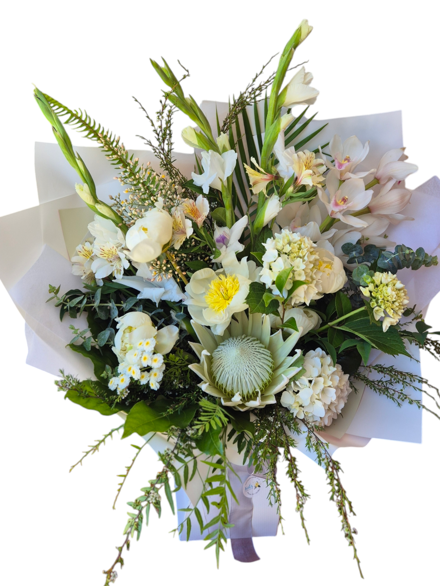 Ivory Whites floral bouquet made with a variety of white and cream flowers and green foliage, wrapped in matching tissue paper.