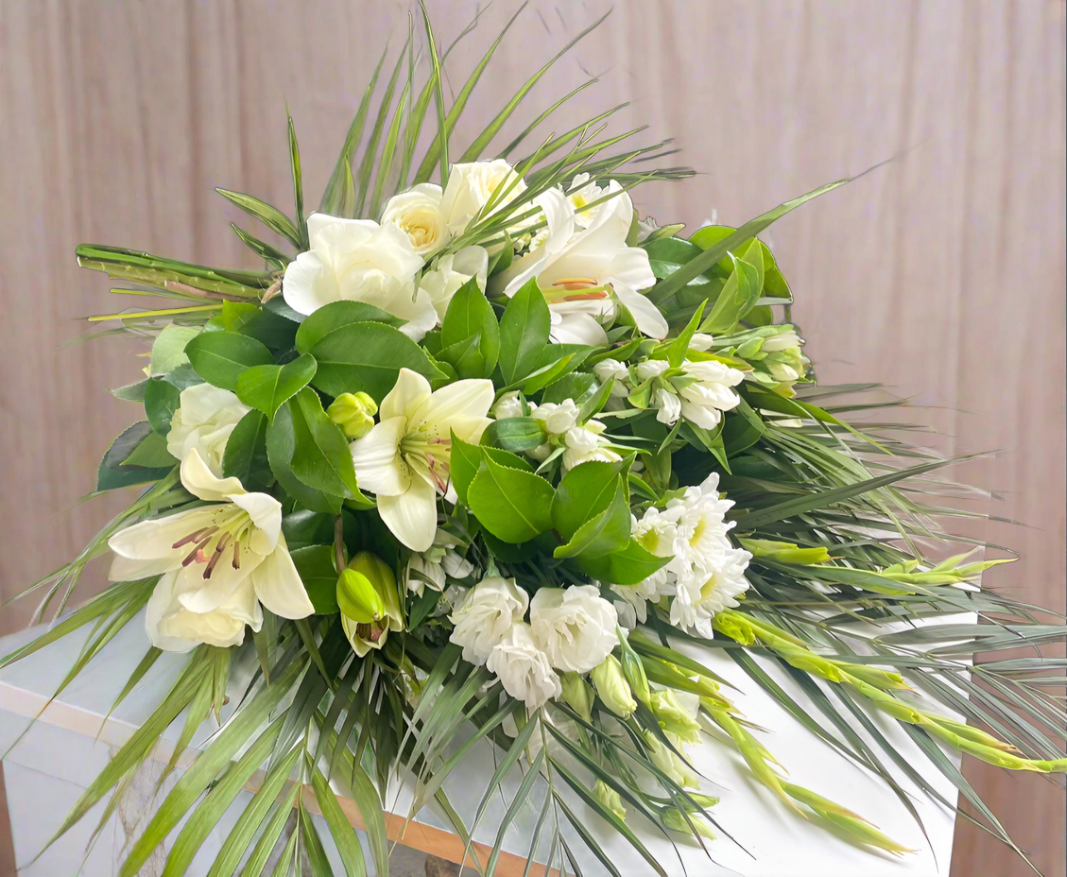 Casket/Funeral Sheaf with an arrangement of white flowers and fresh greenery.