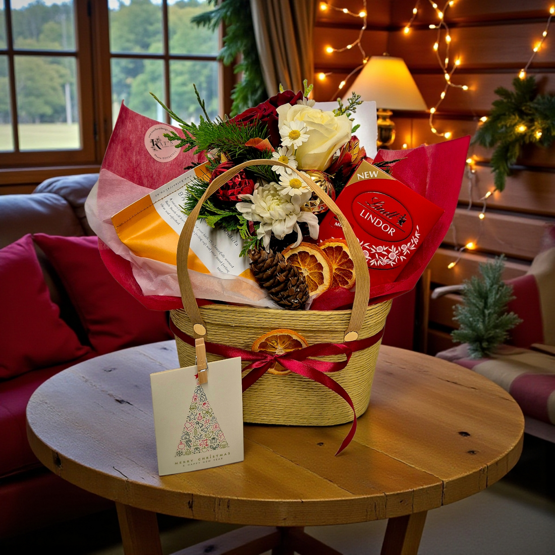Festive Treats Gift Basket with a red and white flower posy, chocolates and bath bomb, presented in a cute basket tied with festive ribbon.
