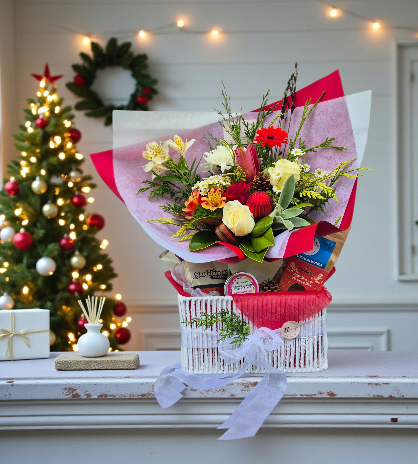 Christmas Cheer Gift Hamper with Medium Bouquet made with festive flowers wrapped in matching paper, complete with local coffee, roasted almonds, flower seed mix and potato chips.