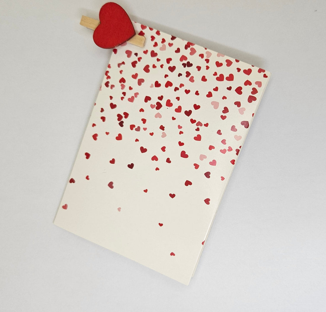 White greeting card with tiny heart details in red and pink.