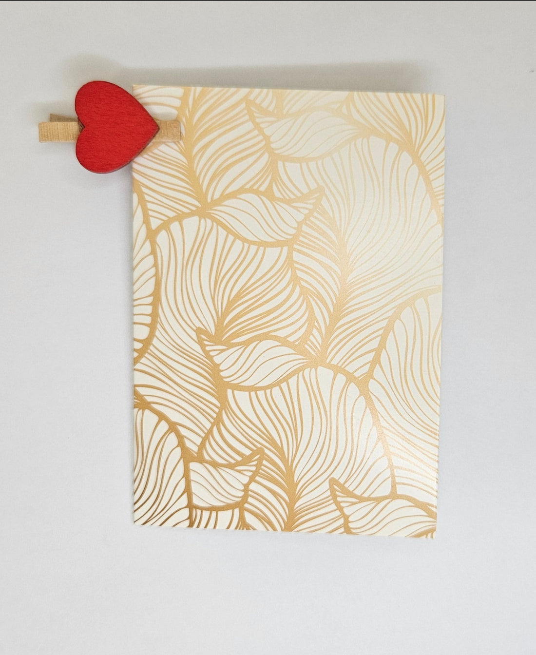 White greeting card with all-over gold leafy detailing.