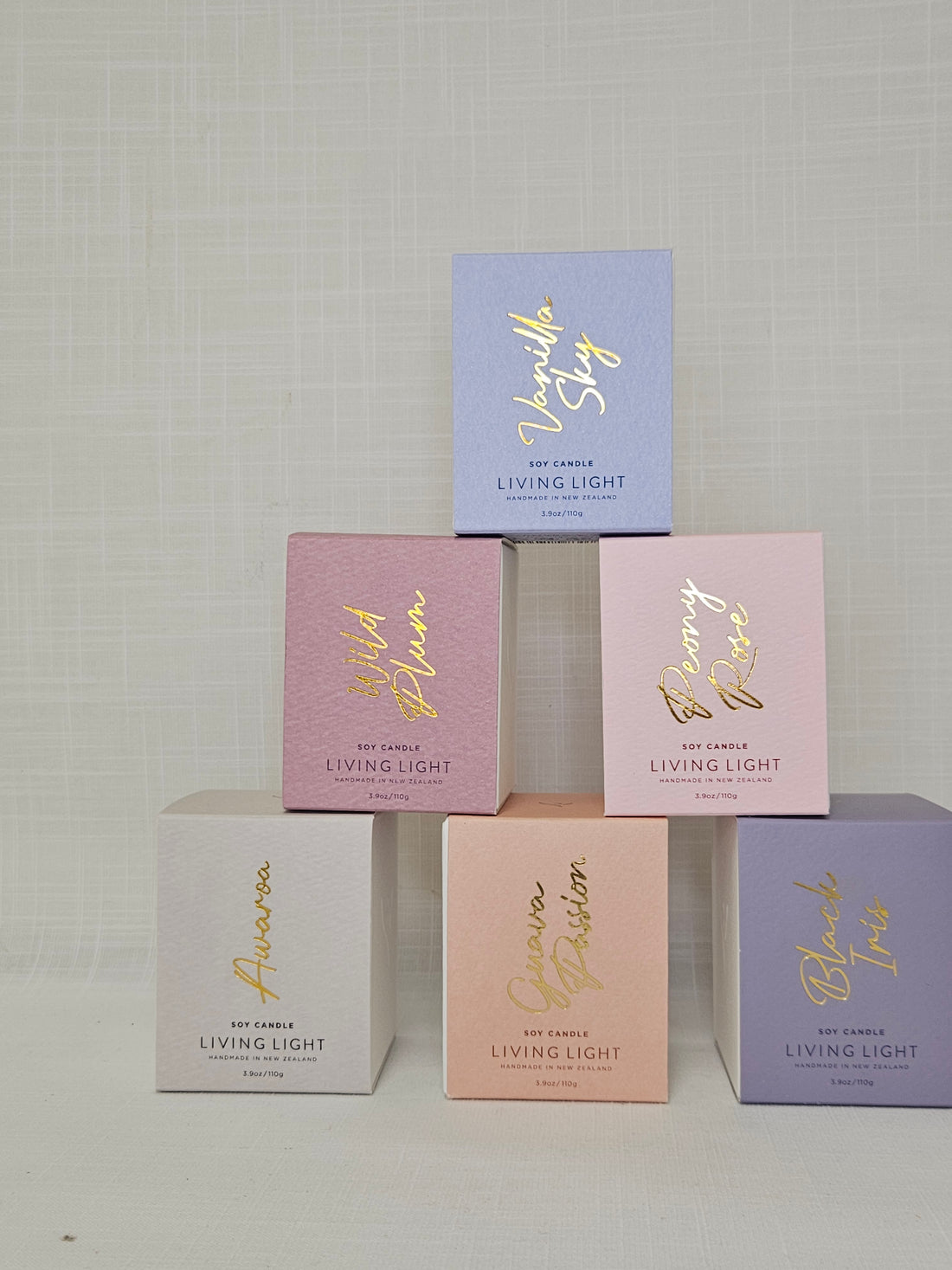 Living Light Soy Mini Candles packaged in pastel boxes, arranged in a pyramid.