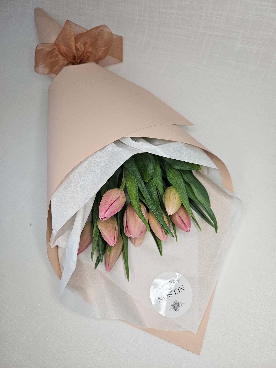 Soft pink Market Tulips wrapped in champagne rose gold paper.