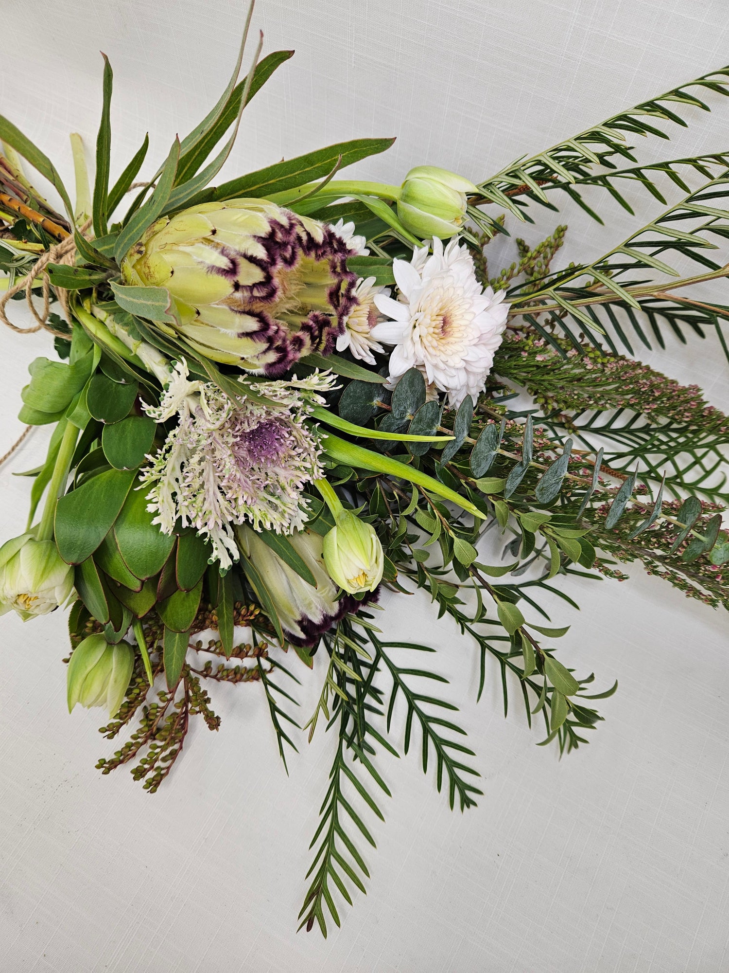 Market Bunch bouquet of neutral coloured flowers and foliage tied with string.