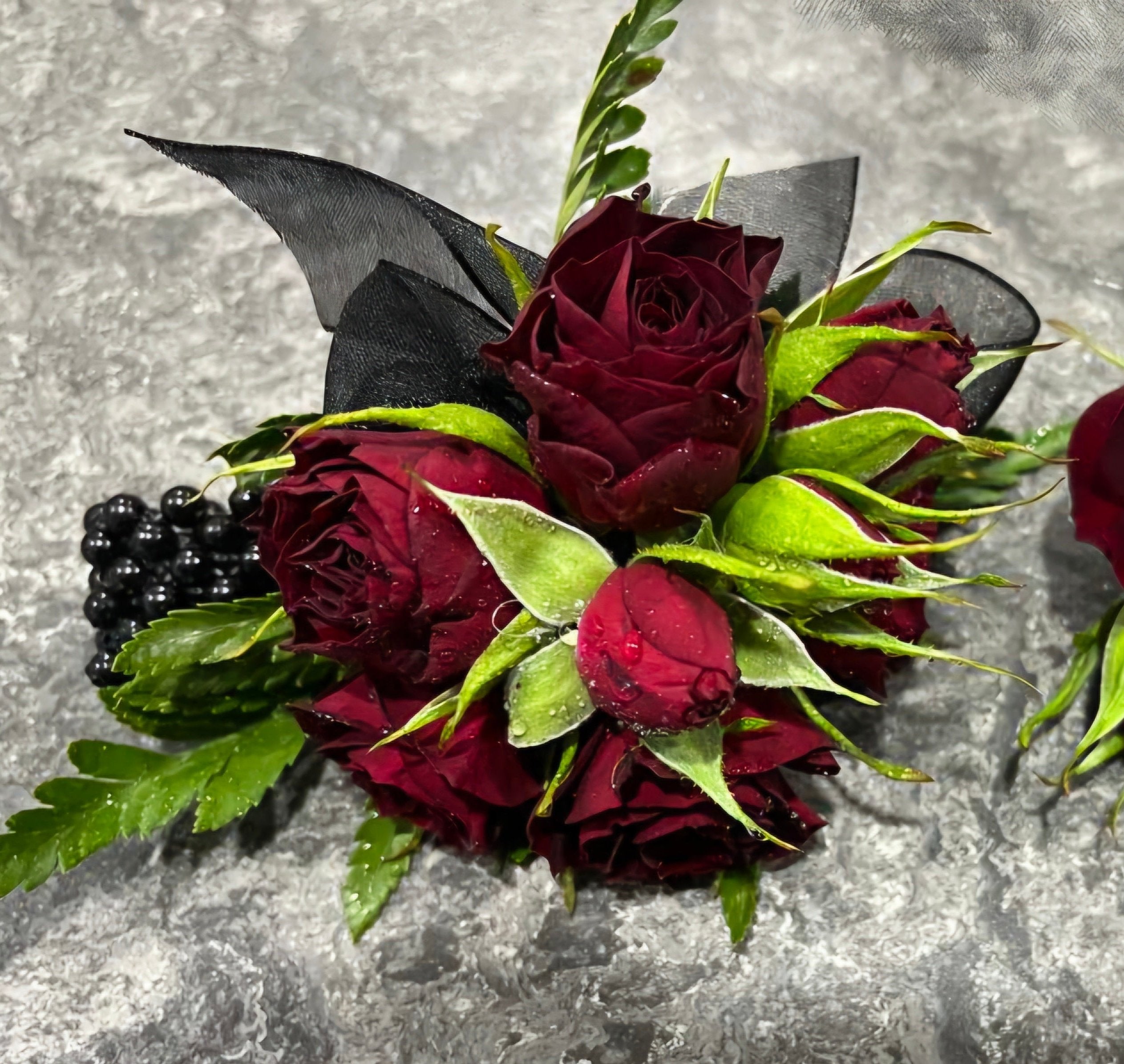 Corsage Duo made with red roses and black ribbon, perfect for school balls.