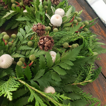 Christmas Greenery Wreath made with pine and other foliage, with added festive white, red and green flowers.