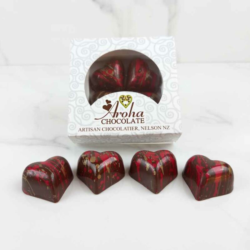 Box of Aroha Chocolate, made in Nelson, New Zealand. Heart-shaped chocolates with red and gold flecks.