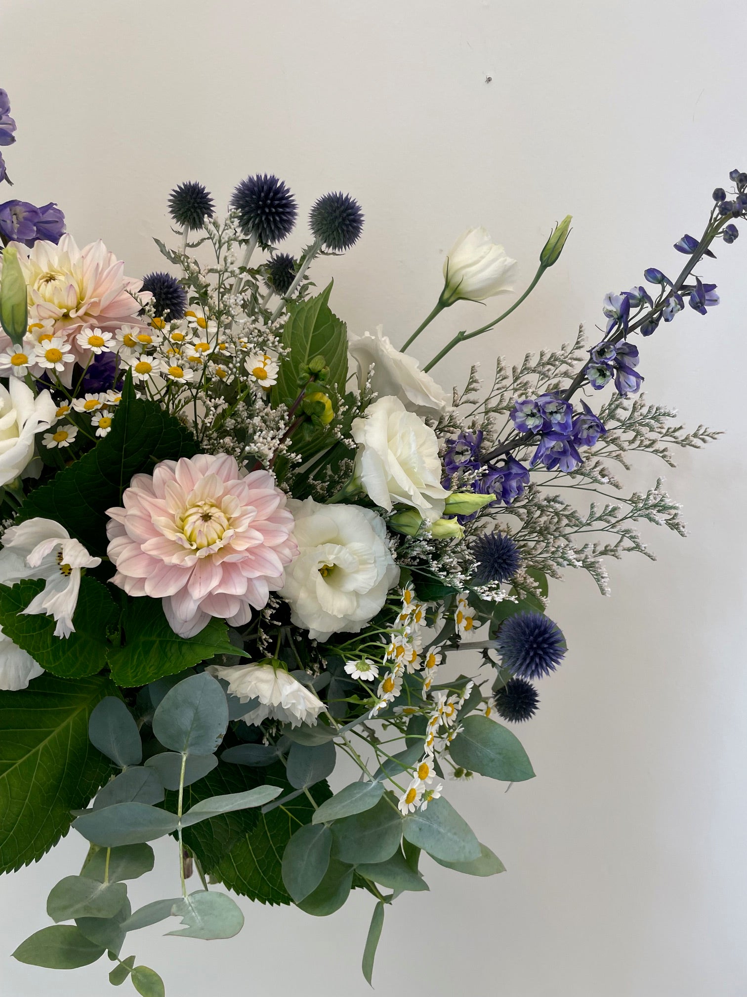 The Sympathy Box floral bouquet made with flowers in soft white and pastel tones with greenery.