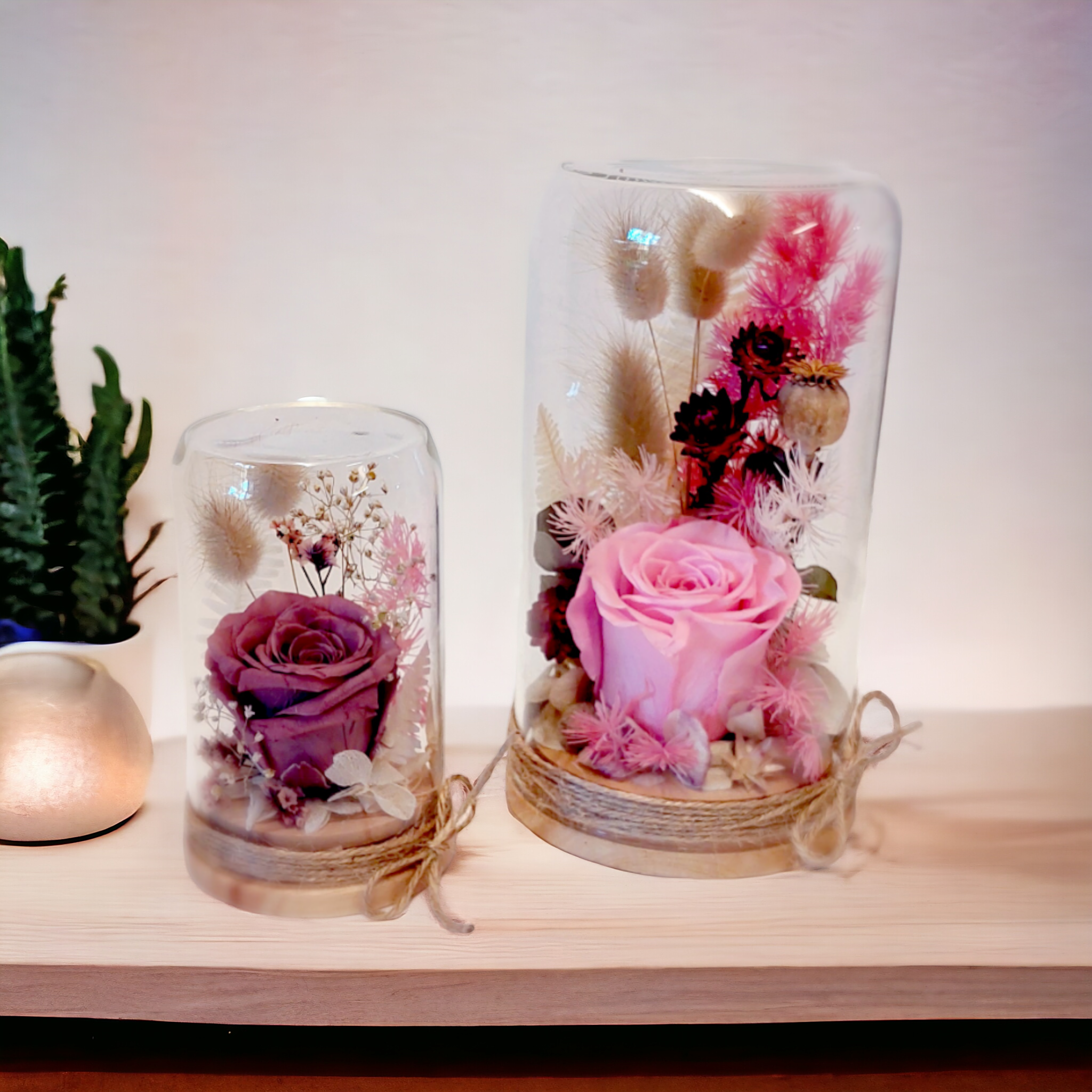 Small and Large Flower Domes containing unique arrangements of pink dried and preserved flowers.