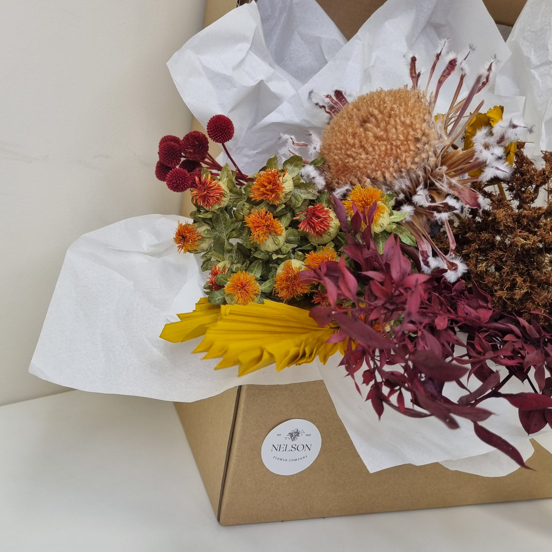 Autumnal Tones Dried Flower Box in cardboard box with white tissue paper.