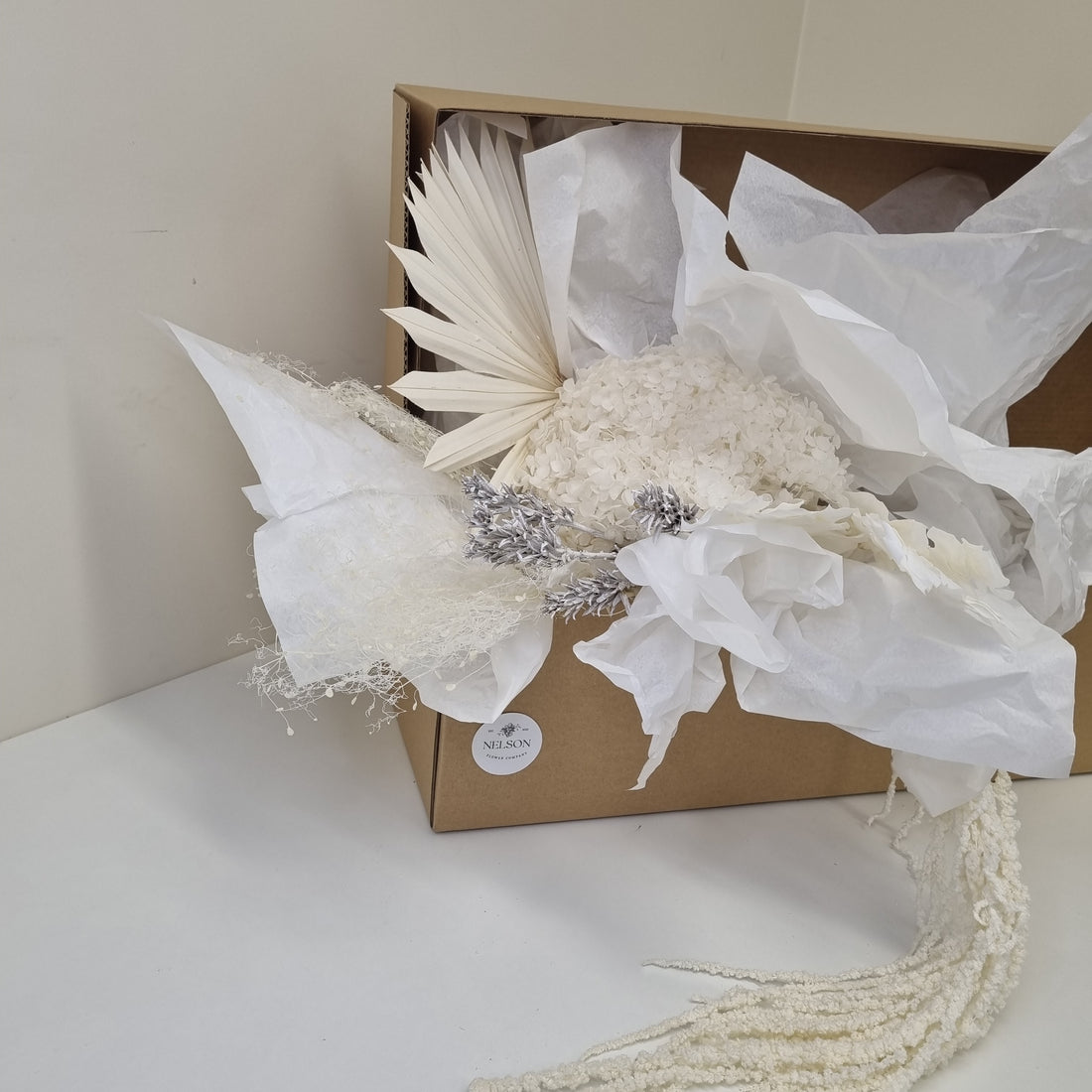 Snow White Dried Flower Box in cardboard box with white tissue paper.