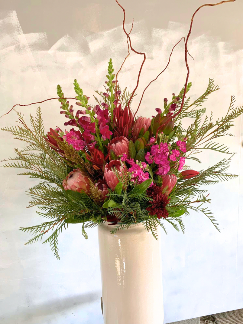 Funeral Vase Arrangement with vibrant seasonal flowers and greenery, arranged in a large vase.