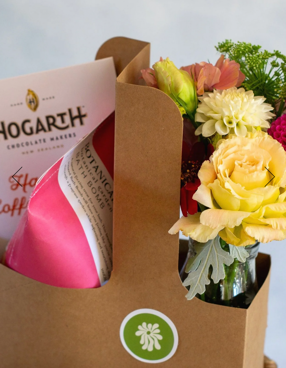 Love You Gift Box, complete with a floral posie made from warm toned fresh flowers, a bar of Hogarth Chocolate and a Botanical Bath Bomb, presented in a brown carry box.