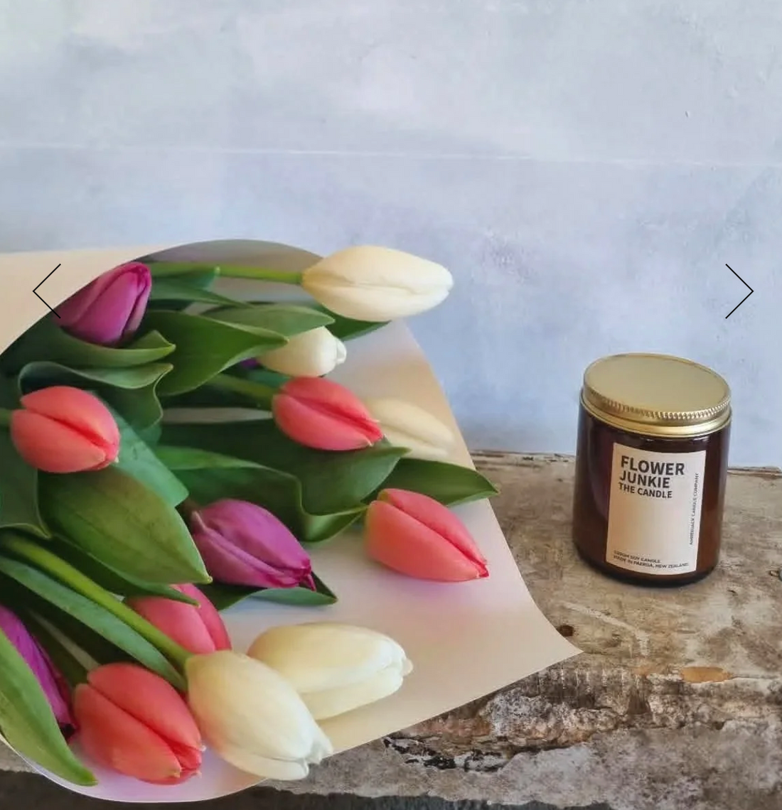 Tulips &amp; Candle Combo gift basket with a selection of pink, purple and white tulips wrapped in a white bouquet, along with a Flower Junkie Amberjack candle.