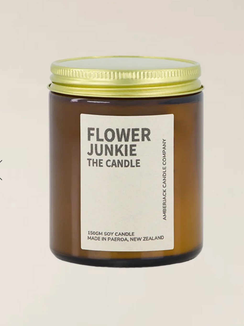 Flower Junkie candle by Amberjack. in a brown jar with a gold screw-top lid.