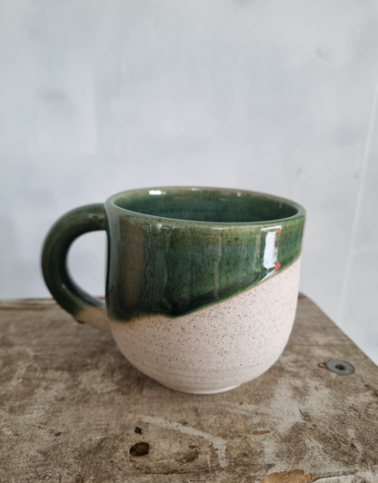 A beautiful handmade mug with half-dipped dark green glaze, by Francis Pottery, as part of the Orchid Giftbox by Flora Flora.