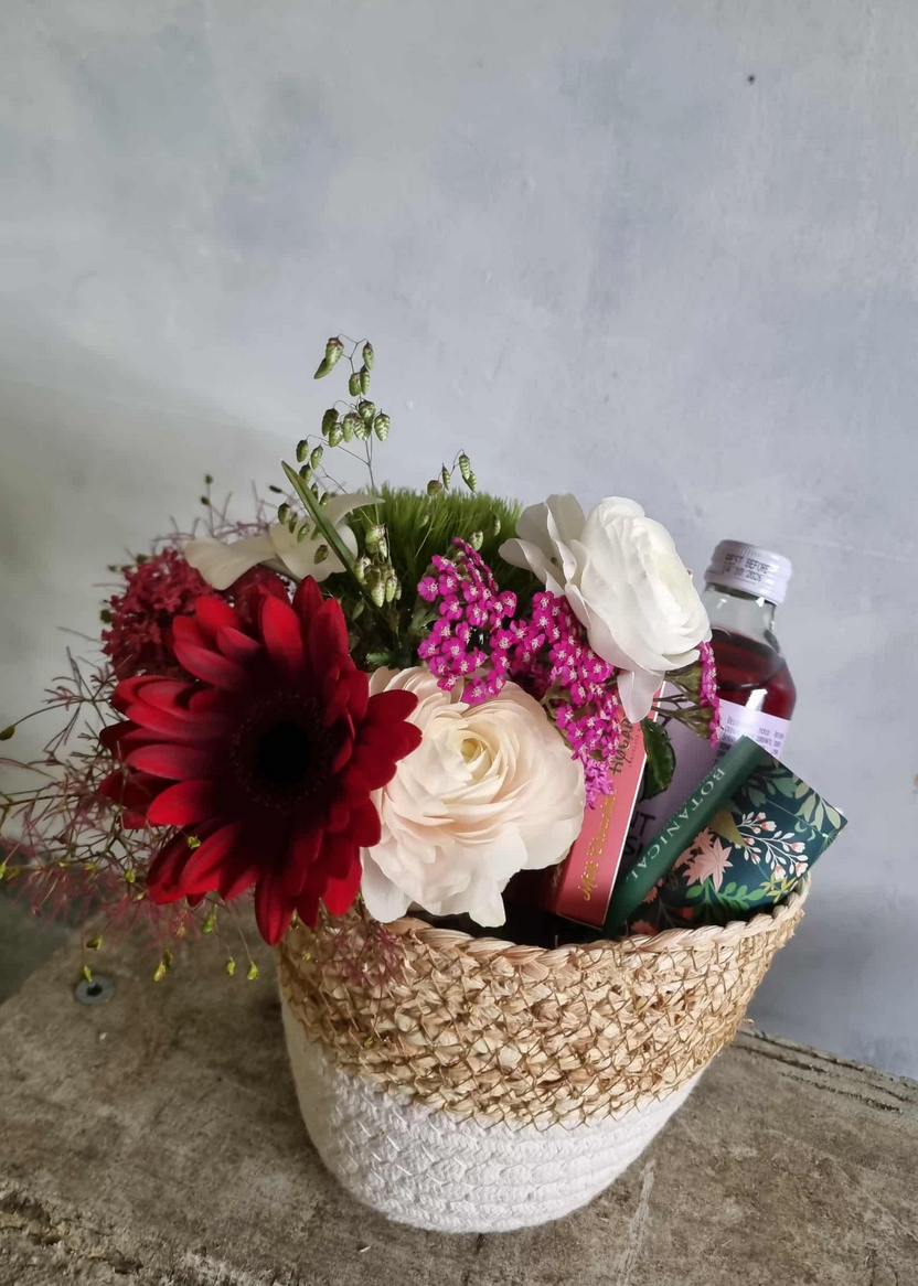 Feeling Festive gift basket complete with floral posie in festive colours, beverage, chocolate and tea lights, presented in a cute basket.