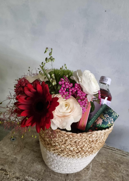 Feeling Festive gift basket complete with floral posie in festive colours, beverage, chocolate and tea lights, presented in a cute basket.