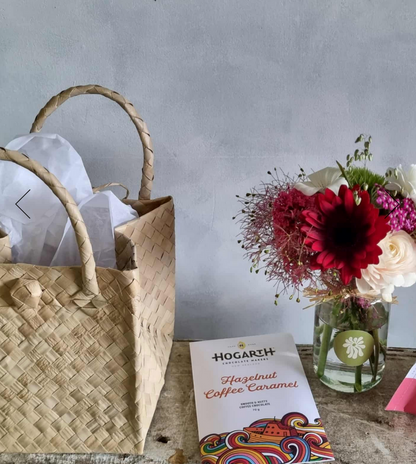 Christmas Kete gift bag complete with festive flower posie, chocolate and a bath bomb, presented in a Māori kete (basket).