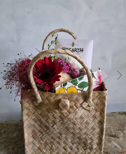 Christmas Kete gift bag complete with festive flower posie, chocolate and a bath bomb, presented in a Māori kete (basket).