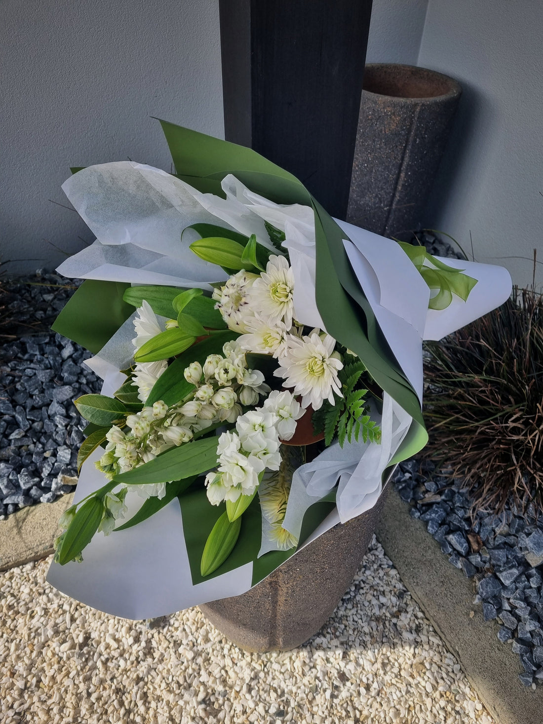 Whites &amp; Greens floral bouquet with white flowers and vibrant green foliage, wrapped in white and green tissue paper.
