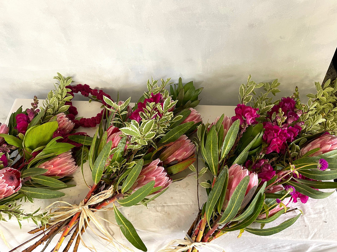 Three Wild Funeral family bouquets with rich pink flowers and soft greenery.