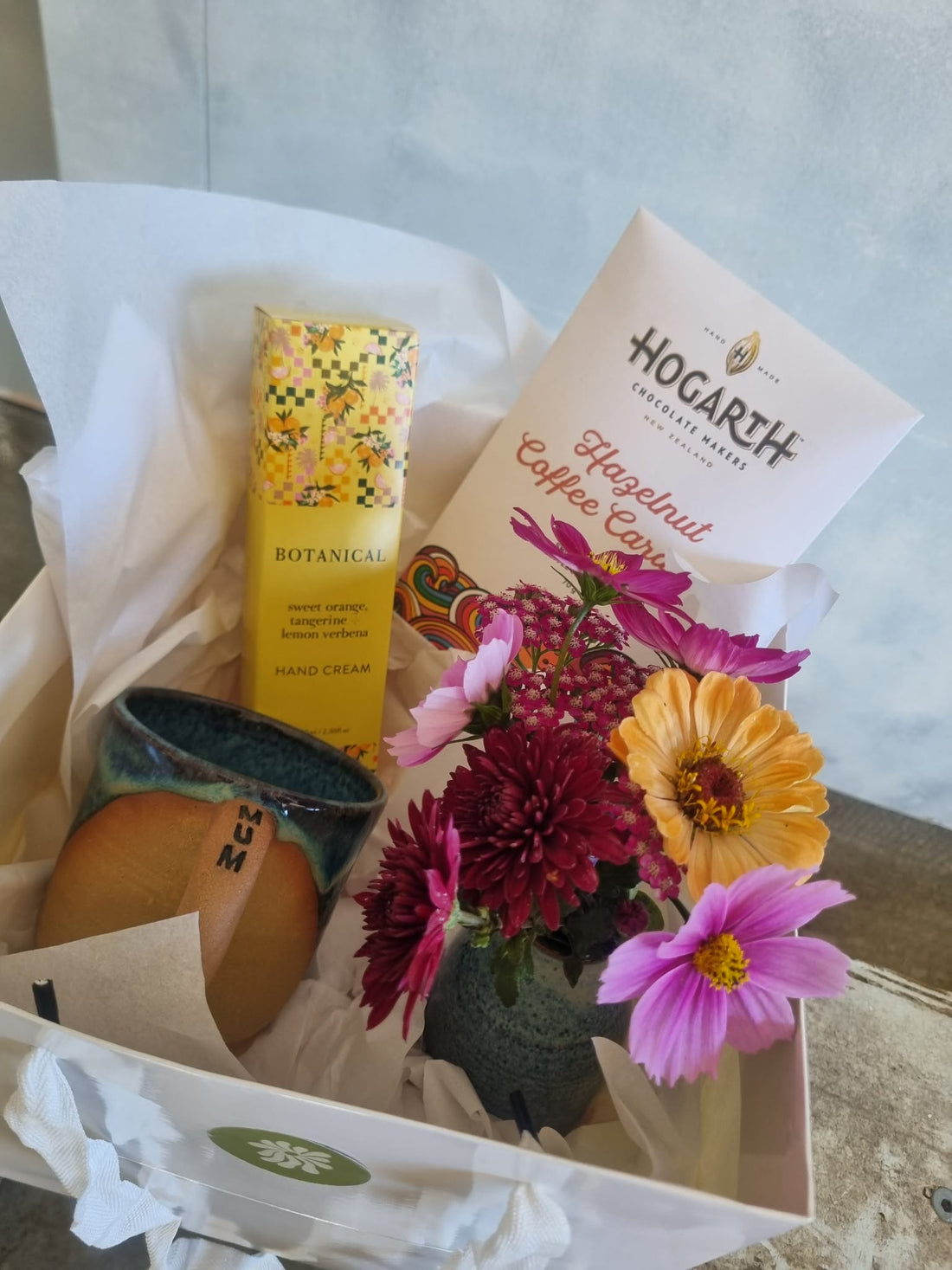 MOTHER gift basket complete with seasonal floral posie, a handmade pottery mug with MUM written on the handle, a small pottery vase, Botanical Hand Cream, and bar of Hogarth&